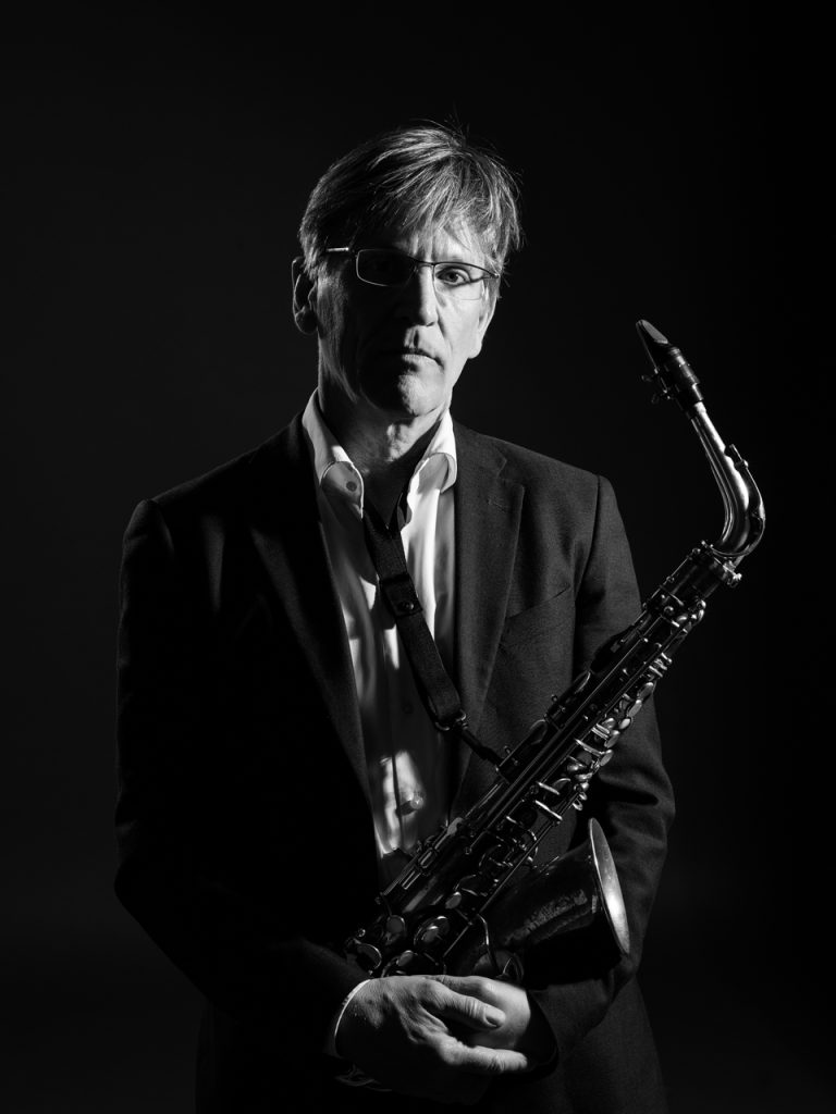 Portrait Michael Hornstein, Musiker hält Saxophon im Arm